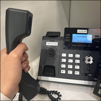The desk phone, receiver in hand